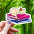 Cat Sleeping on Pride Books Sticker - Brown Cat Bisexual Books - Gifts