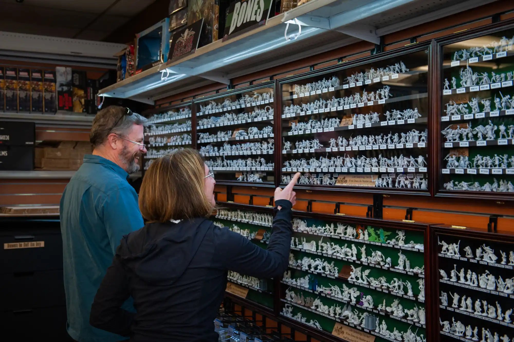 A couple examining a large display of miniature figurines.
