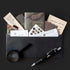 Black leather envelope filled with astrology-themed stationery and accessories for family secrets escape game
