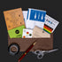 Brown leather envelope with embossed text and contents spilling out for the family secrets escape game kit
