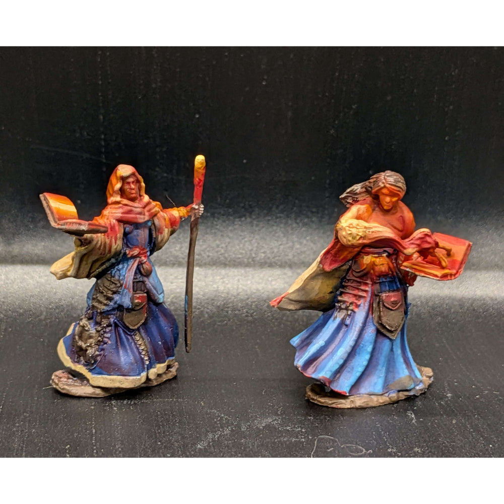Two intricately painted fantasy miniature human wizards in blue and orange robes holding a staff and red-bound tome