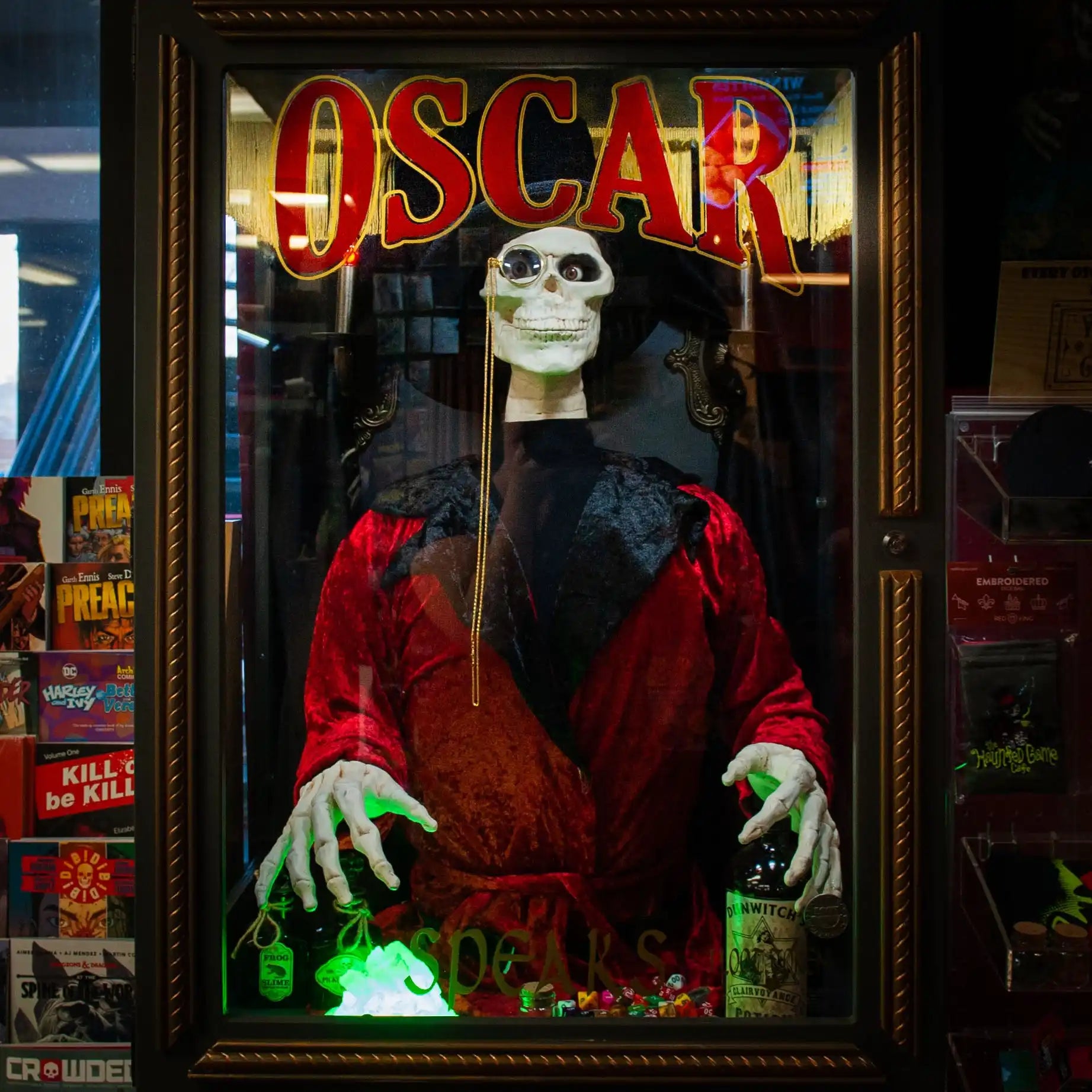 A skeleton mannequin in a red and black robe, wearing a monocle and holding a bottle.