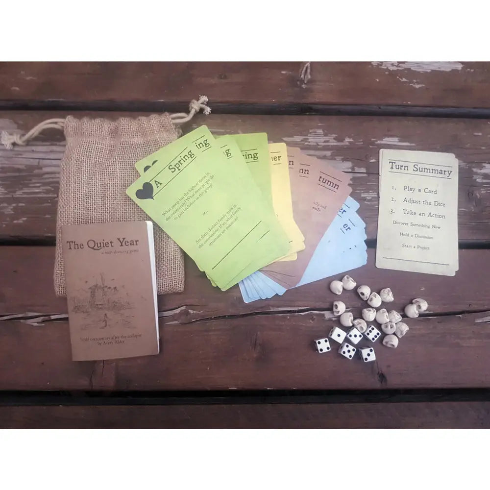 A rustic burlap drawstring bag holding game components for the quiet year rpg board game