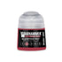 A small cylindrical bottle of warhammer tone pro bloodtoof red paint with a clear cap and black label with white text