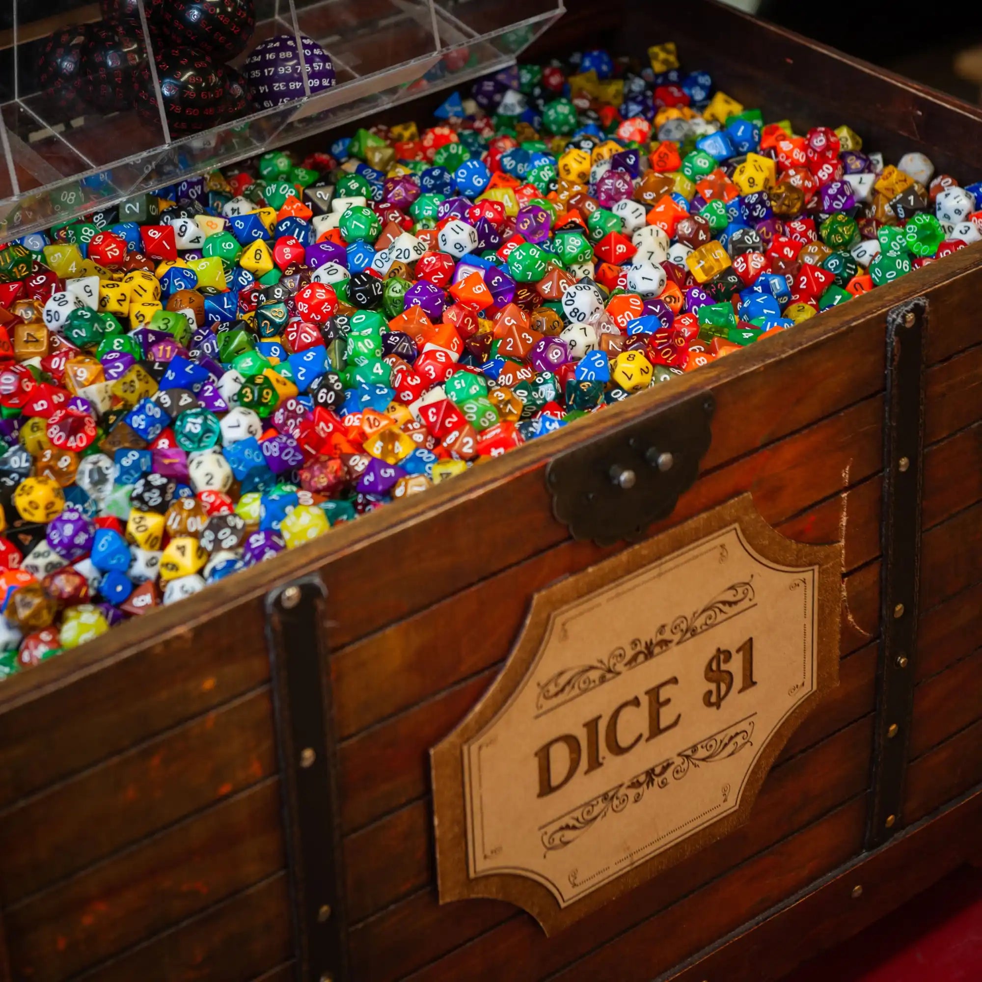 A wooden chest overflowing with colorful, multi-sided dice.